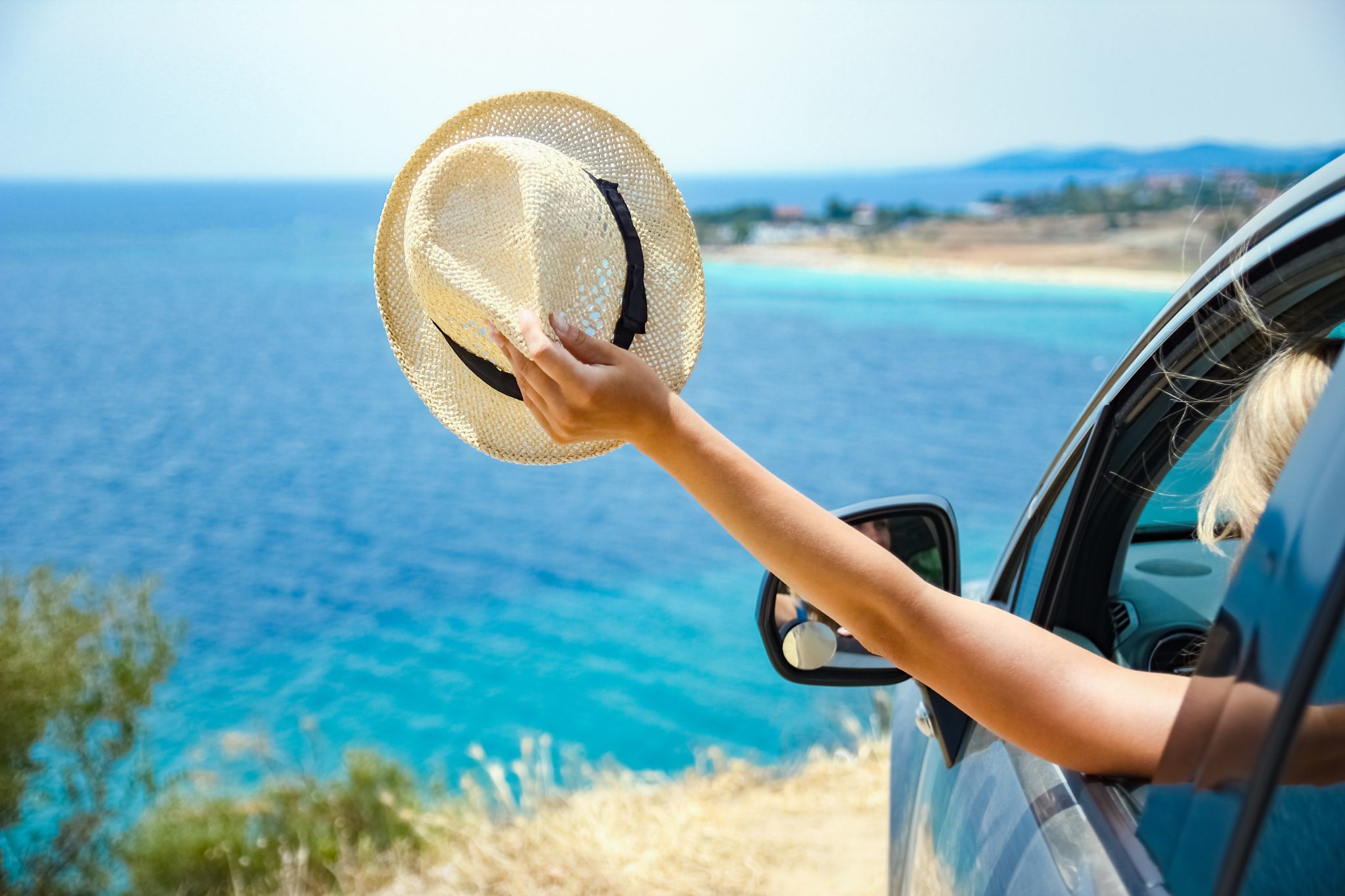 coche de alquiler en formentera con mujer aguantando un sombrero